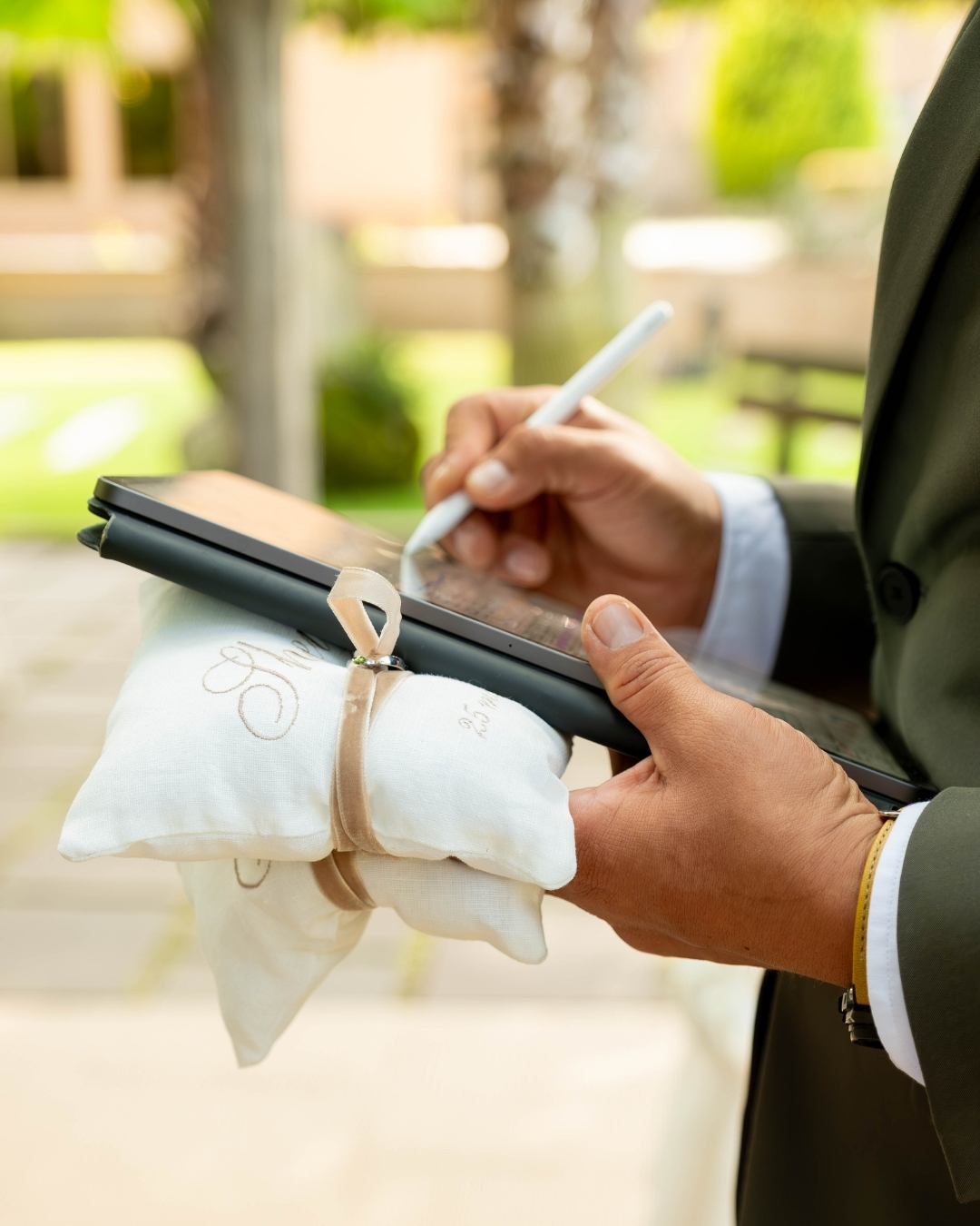 Wedding planner Barcelona coordinando anillos con tablet durante ceremonia de boda